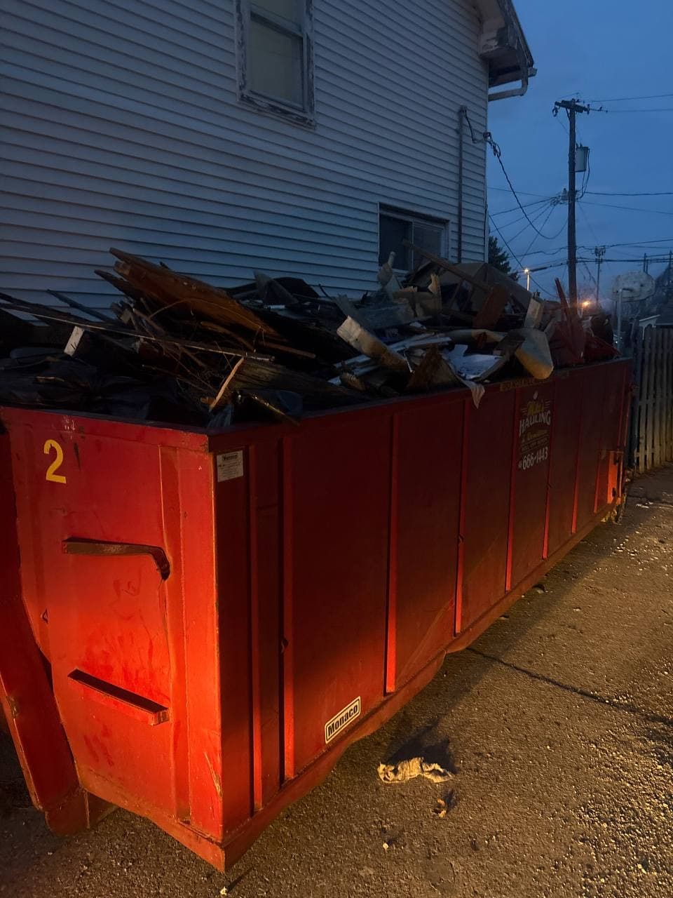 Roll-off dumpster loaded with demo and cleanout debris